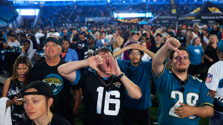 Coleman Marley, center, boos expressing his opinion of NFL Commissioner Roger Goodell kicks off the NFL Draft as Adam Watson gives a thumbs down, right, and Chandler Foster, back, looks on during the Duuuval Draft Party Thursday, April 25, 2024 at EverBank Stadium in Jacksonville, Fla. Thousands came out to watch the Jacksonville Jaguars choose in the 2024 NFL Draft.