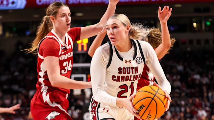 Feb 20, 2025; Columbia, South Carolina, USA; South Carolina Gamecocks forward Chloe Kitts (21) looks to pass around Arkansas Razorbacks forward Jenna Lawrence (34) in the first half at Colonial Life Arena. Mandatory Credit: Jeff Blake-Imagn Images