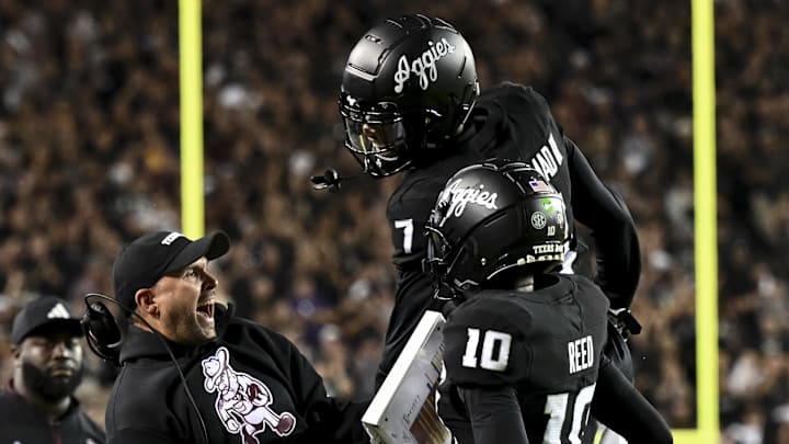 Oct 26, 2024; College Station, Texas, USA; Texas A&M Aggies quarterback Marcel Reed (10) celebrates after scoring a touchdown with Offensive Coordinator/Quarterbacks coach Collin Klein in the third quarter against the LSU Tigers at Kyle Field. Mandatory Credit: Maria Lysaker-Imagn Images. 