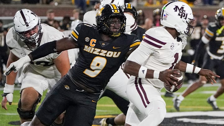 Nov 15, 2025; Columbia, Missouri, USA; Mississippi State Bulldogs quarterback Kamario Taylor (1) runs the ball as Missouri Tigers defensive end Zion Young (9) attempts the sack during the second half of the game at Faurot Field at Memorial Stadium. Mandatory Credit: Denny Medley-Imagn Images