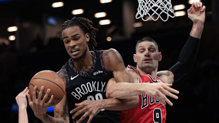 Jan 16, 2026; Brooklyn, New York, USA; Brooklyn Nets center Nic Claxton (33) rebounds against Chicago Bulls center Nikola Vucevic (9) during the second half at Barclays Center. Mandatory Credit: Vincent Carchietta-Imagn Images