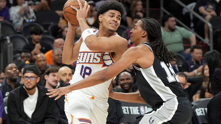 Oct 10, 2026; Phoenix, Arizona, USA; Phoenix Suns forward Koa Peat (18) shields the ball from San Antonio Spurs guard RJ Davis (14) in the second half at Mortgage Matchup Center. Mandatory Credit: Rick Scuteri-Imagn Images Oct 10, 2026; Phoenix, Arizona, USA; Phoenix Suns forward Koa Peat (18) shields the ball from San Antonio Spurs guard RJ Davis (14) in the second half at Mortgage Matchup Center. Mandatory Credit: Rick Scuteri-Imagn Images
