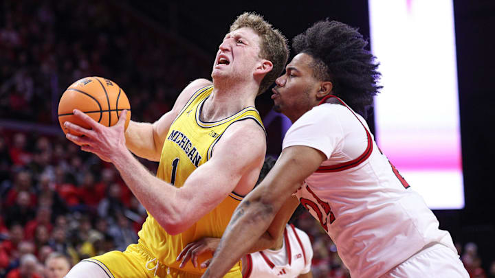 Michigan Wolverines center Danny Wolf (1) drives to the basket against Rutgers Scarlet Knights center Lathan Sommerville (24) in a Big Ten men's basketball matchup.