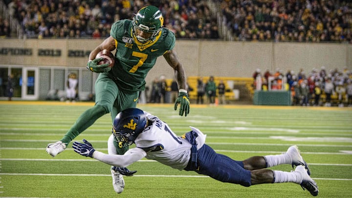 Oct 31, 2019; Waco, TX, USA; Baylor Bears running back John Lovett (7) tries to leap West Virginia Mountaineers safety Kerry Martin Jr. (15) during the second quarter at McLane Stadium. Mandatory Credit: Jerome Miron-Imagn Images