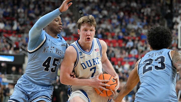Mar 21, 2025; Raleigh, NC, USA; Mount St. Mary's Mountaineers guard Xavier Lipscomb (45) and guard Javon Ervin (23) defend Duke Blue Devils guard Kon Knueppel (7) during the second half in the first round of the NCAA Tournament at Lenovo Center. Mandatory Credit: Zachary Taft-Imagn Images