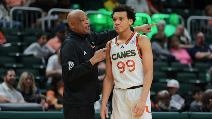 Feb 1, 2025; Coral Gables, Florida, USA; Miami Hurricanes interim head coach Bill Courtney talks to guard Divine Ugochukwu (99) during the first half against the Notre Dame Fighting Irish at Watsco Center. Mandatory Credit: Sam Navarro-Imagn Images