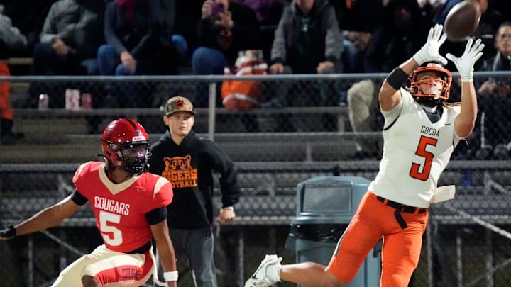 Cocoa High wide receiver Jayvan Boggs (#5) pulls in a pass along the sideline. Cocoa High School defeated Cardinal Mooney Catholic High School 31-21 to win the Class 2A semi-final game Friday night in Sarasota.