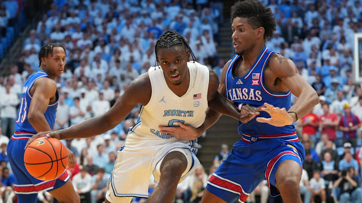 Nov 7, 2025; Chapel Hill, North Carolina, USA;  North Carolina Tar Heels forward Caleb Wilson (8) with the ball as Kansas Jayhawks forward Samis Calderon (6) defends in the second half at Dean E. Smith Center. Mandatory Credit: Bob Donnan-Imagn Images