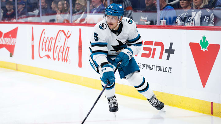 Oct 18, 2024; Winnipeg, Manitoba, CAN;  San Jose Sharks defenseman Matt Benning (5) looks to make a pass against the Winnipeg Jets during the second period at Canada Life Centre. Mandatory Credit: Terrence Lee-Imagn Images