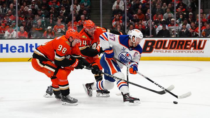 Apr 30, 2026; Anaheim, California, USA; Edmonton Oilers center Connor McDavid (97) handles the puck against Anaheim Ducks defenseman Pavel Mintyukov (98) and defenseman John Carlson (74) in the first period of game six of the first round of the 2026 Stanley Cup Playoffs at Honda Center. Mandatory Credit: Kirby Lee-Imagn Images