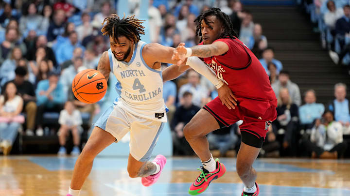 Feb 19, 2025; Chapel Hill, North Carolina, USA; North Carolina Tar Heels guard RJ Davis (4) with the ball as North Carolina State Wolfpack guard Jayden Taylor (8) defends in the second half at Dean E. Smith Center. Mandatory Credit: Bob Donnan-Imagn Images