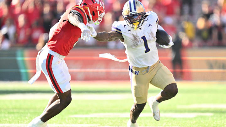 Huskies running back Jonah Coleman (1) stiff-arms Maryland linebacker Trey Reddick. Huskies running back Jonah Coleman (1) stiff-arms Maryland linebacker Trey Reddick.