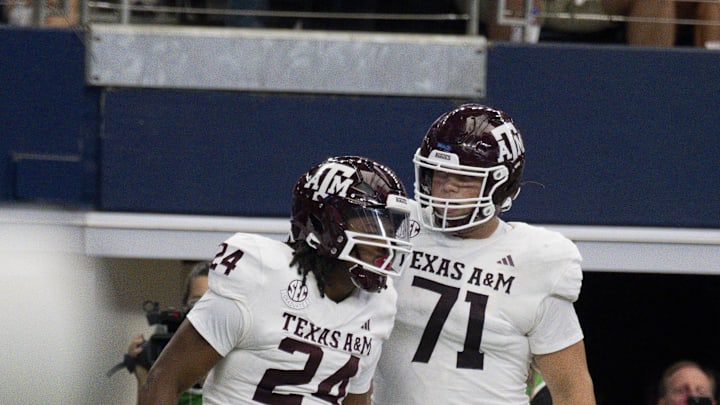 Sep 30, 2023; Arlington, Texas, USA; Texas A&M Aggies running back Earnest Crownover (24) and offensive lineman Chase Bisontis (71) celebrate after Crownover scores a touchdown against the Arkansas Razorbacks during the first half at AT&T Stadium. Mandatory Credit: Jerome Miron-Imagn Images