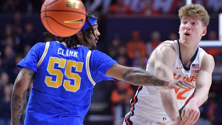 Feb 11, 2025; Champaign, Illinois, USA;  Illinois Fighting Illini guard Kasparas Jakucionis (32) passes the ball by UCLA Bruins guard Skyy Clark (55)  during the first half at State Farm Center. Mandatory Credit: Ron Johnson-Imagn Images