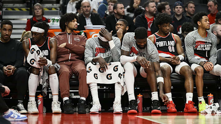 Mar 11, 2024; Portland, Oregon, USA; The Portland Trail Blazers bench, from left, guard Malcolm Brogdon (11), guard Shaedon Sharpe (17), center Duop Reath (26), center Deandre Ayton (2), guard Scoot Henderson (00), and guard Anfernee Simons (1) watch the final minutes of a game against the Boston Celtics at Moda Center. Mandatory Credit: Troy Wayrynen-Imagn Images