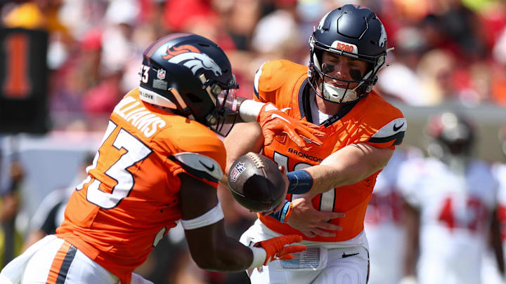 Sep 22, 2024; Tampa, Florida, USA; Denver Broncos quarterback Bo Nix (10) hands off to running back Javonte Williams (33) against the Tampa Bay Buccaneers in the first quarter at Raymond James Stadium. 