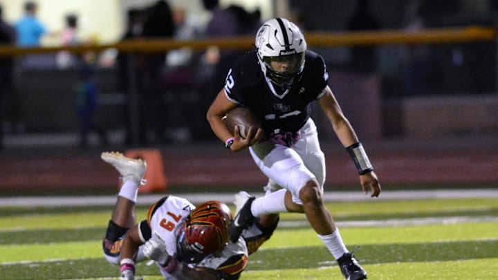 Knight quarterback Xavier Perez escapes the tackle attempt from Hawk lineman Abel Gonzalez as the Centennial Hawks met the Organ Mountain Knights on Friday night, October 18, 2024.