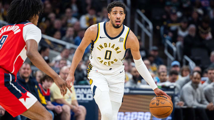 Apr 8, 2025; Indianapolis, Indiana, USA; Indiana Pacers guard Tyrese Haliburton (0) dribbles the ball while Washington Wizards forward Justin Champagnie (9) defends in the first half at Gainbridge Fieldhouse. Mandatory Credit: Trevor Ruszkowski-Imagn Images