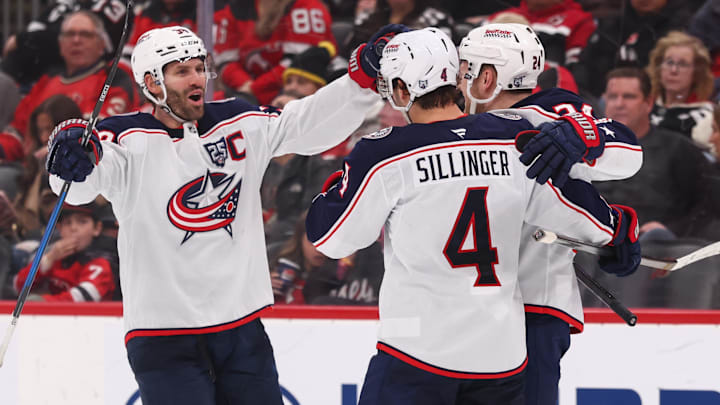 Blue Jackets players Boone Jenner, Cole Sillinger, and Mathieu Olivier celebrate a goal against the New Jersey Devils.