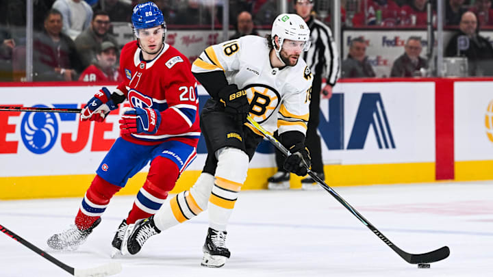 Mar 17, 2026; Montreal, Quebec, CAN; Boston Bruins center Pavel Zacha (18) plays the puck against Montreal Canadiens left wing Juraj Slafkovsky (20) during the first period at Bell Centre. Mandatory Credit: David Kirouac-Imagn Images