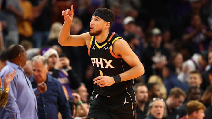 Dec 3, 2024; Phoenix, Arizona, USA; Phoenix Suns guard Devin Booker (1) celebrates after scoring his 15,000th NBA point against the San Antonio Spurs in the first half of an NBA Cup game at Footprint Center. Mandatory Credit: Mark J. Rebilas-Imagn Images