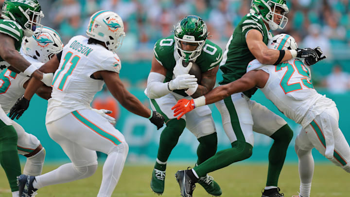 Dec 8, 2024; Miami Gardens, Florida, USA; New York Jets running back Braelon Allen (0) runs with the football against Miami Dolphins linebacker Tyrel Dodson (11) and cornerback Kendall Fuller (29) during the third quarter at Hard Rock Stadium. Mandatory Credit: Sam Navarro-Imagn Images