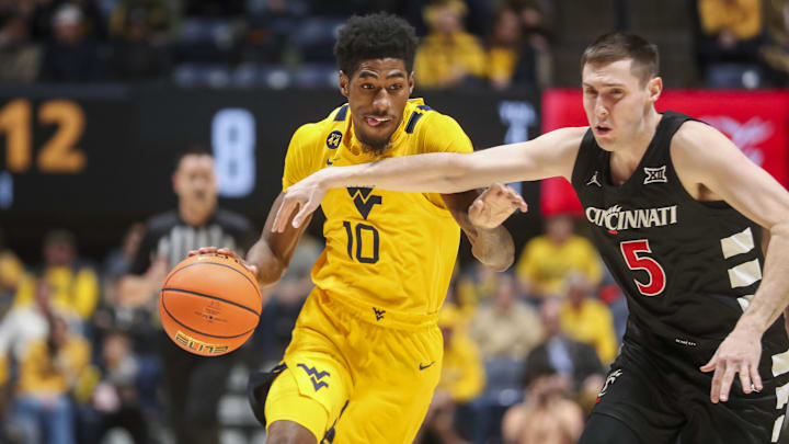 Feb 19, 2025; Morgantown, West Virginia, USA; West Virginia Mountaineers guard Sencire Harris (10) drives against Cincinnati Bearcats guard CJ Fredrick Jr. (5) during the first half at WVU Coliseum. Mandatory Credit: Ben Queen-Imagn Images