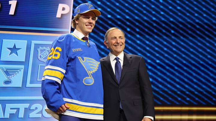 Jun 26, 2026; Buffalo, New York, USA; Tynan Lawrence poses beside NHL commissioner Gary Bettman after being selected with the eleventh pick in the first round of the 2026 NHL Draft by the St. Louis Blues at KeyBank Center. Mandatory Credit: Timothy T. Ludwig-Imagn Images