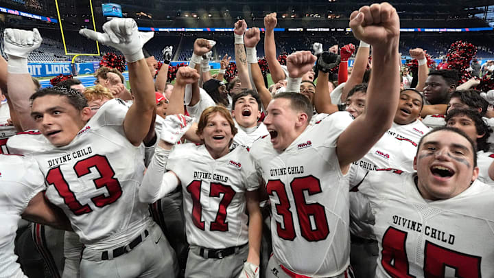 Dearborn Divine Child celebrates and do a cheer in front of students after beating Hudsonville Unity Christian 23-22 in the MHSAA Division 4 football championship at Ford Field in Detroit on Friday, Nov. 28, 2025.