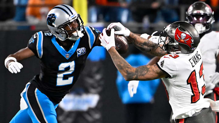 Dec 1, 2024; Charlotte, North Carolina, USA;  Tampa Bay Buccaneers wide receiver Mike Evans (13) catches the ball as Carolina Panthers cornerback Michael Jackson (2) defends in overtime at Bank of America Stadium. Mandatory Credit: Bob Donnan-Imagn Images