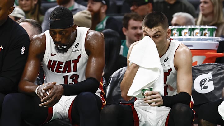 Dec 2, 2024; Boston, Massachusetts, USA; Miami Heat players (left to right) center Bam Adebayo (13), guard Tyler Herro (14), guard Terry Rozier (2) and forward Duncan Robinson (55) sit on the bench during the fourth quarter of their loss to the Boston Celtics at TD Garden. Mandatory Credit: Winslow Townson-Imagn Images