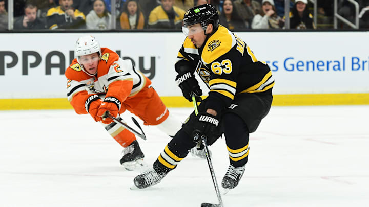 Feb 22, 2025; Boston, Massachusetts, USA; Boston Bruins left wing Brad Marchand (63) controls the puck against Anaheim Ducks defenseman Jackson LaCombe (2) during the first period at TD Garden. Mandatory Credit: Bob DeChiara-Imagn Images