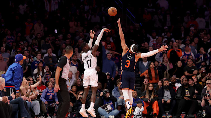 Nov 15, 2024; New York, New York, USA; Brooklyn Nets guard Dennis Schroder (17) shoots a three point shot against New York Knicks guard Josh Hart (3) during the fourth quarter at Madison Square Garden. Mandatory Credit: Brad Penner-Imagn Images