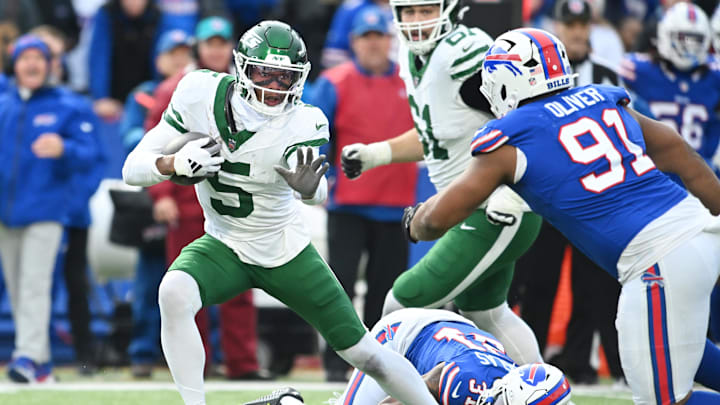 Dec 29, 2024; Orchard Park, New York, USA; New York Jets wide receiver Garrett Wilson (5) tries to avoid Buffalo Bills defensive tackle Ed Oliver (91) after making a catch in the third quarter at Highmark Stadium. Mandatory Credit: Mark Konezny-Imagn Images