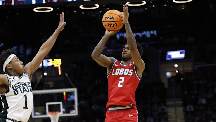 Mar 23, 2025; Cleveland, OH, USA; New Mexico Lobos guard Donovan Dent (2) shoots the ball over Michigan State Spartans guard Jeremy Fears Jr. (1) in the second half during the NCAA Tournament Second Round at Rocket Arena. Mandatory Credit: Rick Osentoski-Imagn Images Mar 23, 2025; Cleveland, OH, USA; New Mexico Lobos guard Donovan Dent (2) shoots the ball over Michigan State Spartans guard Jeremy Fears Jr. (1) in the second half during the NCAA Tournament Second Round at Rocket Arena. Mandatory Credit: Rick Osentoski-Imagn Images