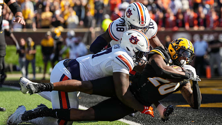 Oct 19, 2024; Columbia, Missouri, USA; Missouri Tigers running back Jamal Roberts (20) scores a touchdown against Auburn Tigers cornerback Mac McClinton (27) and safety Kaleb Harris (18) during the second half at Faurot Field at Memorial Stadium. Mandatory Credit: Jay Biggerstaff-Imagn Images Oct 19, 2024; Columbia, Missouri, USA; Missouri Tigers running back Jamal Roberts (20) scores a touchdown against Auburn Tigers cornerback Mac McClinton (27) and safety Kaleb Harris (18) during the second half at Faurot Field at Memorial Stadium. Mandatory Credit: Jay Biggerstaff-Imagn Images