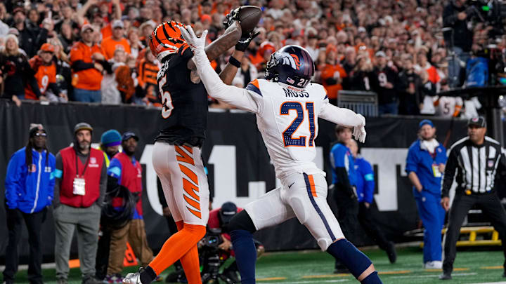 Cincinnati Bengals wide receiver Tee Higgins (5) catches a touchdown pass over Denver Broncos cornerback Riley Moss (21) in the fourth quarter of the NFL Week 17 game between the Cincinnati Bengals and the Denver Broncos at Paycor Stadium in downtown Cincinnati on Saturday, Dec. 28, 2024. The Bengals took a 30-24 win in overtime to remain in the post season chase.