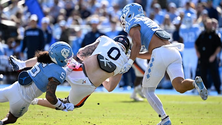 Oct 25, 2025; Chapel Hill, North Carolina, USA; Virginia Cavaliers tight end Sage Ennis (0) with the ball as North Carolina Tar Heels defensive back Gavin Gibson (5) and defensive back Will Hardy (31) defend in the first quarter at Kenan Stadium. Mandatory Credit: Bob Donnan-Imagn Images Oct 25, 2025; Chapel Hill, North Carolina, USA; Virginia Cavaliers tight end Sage Ennis (0) with the ball as North Carolina Tar Heels defensive back Gavin Gibson (5) and defensive back Will Hardy (31) defend in the first quarter at Kenan Stadium. Mandatory Credit: Bob Donnan-Imagn Images