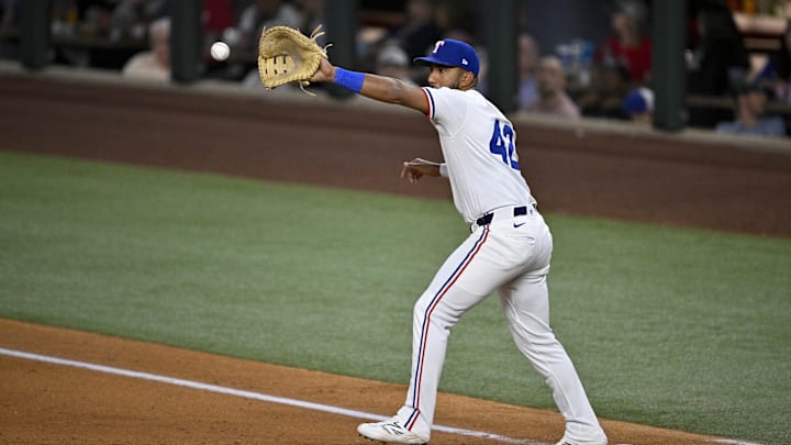 Apr 15, 2025; Arlington, Texas, USA; Texas Rangers first baseman Ezequiel Duran fields a throw to first base during the fifth inning against the Los Angeles Angels at Globe Life Field. All MLB players will be wearing the number 42 on Jackie Robinson Day to commemorate Robinson making his major league debut in 1947. Mandatory Credit: Jerome Miron-Imagn Images