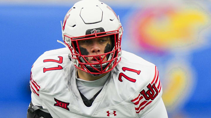 Nov 28, 2025; Lawrence, Kansas, USA; Utah Utes offensive lineman Caleb Lomu (71) gets ready before the snap during the second half against the Kansas Jayhawks at David Booth Kansas Memorial Stadium. Mandatory Credit: Jay Biggerstaff-Imagn Images