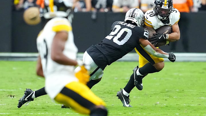 Oct 13, 2024; Paradise, Nevada, USA; Pittsburgh Steelers running back Jaylen Warren (30) looks to evade the tackle attempt of Las Vegas Raiders safety Isaiah Pola-Mao (20) during the third quarter at Allegiant Stadium. Mandatory Credit: Stephen R. Sylvanie-Imagn Images