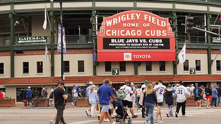 Fans walk past signage announcing that Sunday's game between the Chicago Cubs and the Toronto Blue Jays has been postponed. Fans walk past signage announcing that Sunday's game between the Chicago Cubs and the Toronto Blue Jays has been postponed.