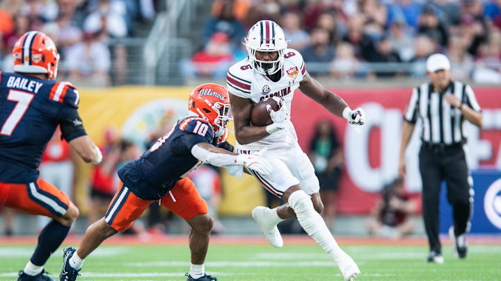 Dec 31, 2024; Orlando, FL, USA; South Carolina Gamecocks running back Dylan Stewart (6) runs the ball against Illinois Fighting Illini defensive back Miles Scott (10) in the third quarter at Camping World Stadium. Mandatory Credit: Jeremy Reper-Imagn Images
