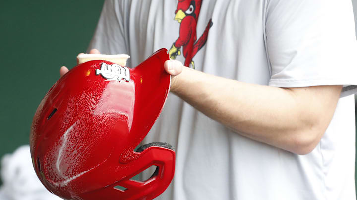 Jul 3, 2024; Pittsburgh, Pennsylvania, USA;  A St. Louis Cardinals equipment manager shines the batting helmets prior to a game against the Pittsburgh Pirates at PNC Park. Mandatory Credit: Charles LeClaire-Imagn Images