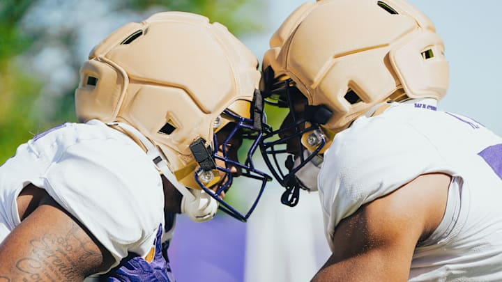 Buddah Al-Uqdah, left, and Anthony Ward knock heads in a UW linebacker drill. 