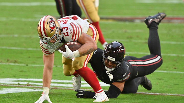 Nov 16, 2025; Glendale, Arizona, USA; San Francisco 49ers running back Christian McCaffrey (23) attempts to evade a tackle from Arizona Cardinals inside linebacker Cody Simon (50) in the third quarter at State Farm Stadium. Mandatory Credit: Matt Kartozian-Imagn Images
