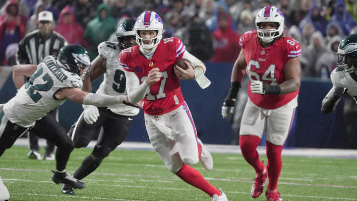 Buffalo Bills quarterback Josh Allen runs with the ball for several yards before being tripped up by Philadelphia Eagles linebacker Jalyx Hunt during first half action against the Philadelphia Eagles at Highmark Stadium in Orchard Park on Dec. 28, 2025.
