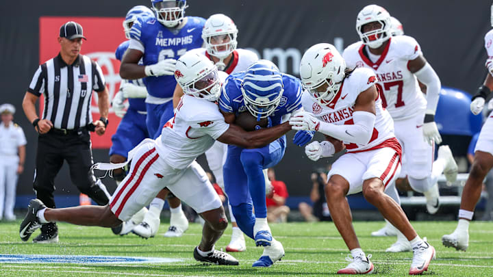 Sep 20, 2025; Memphis, Tennessee, USA; Memphis Tigers running back Greg Desrosiers Jr. (13) is tackled by Arkansas Razorbacks defensive back Larry Worth III (3) and defensive back Julian Neal (23) during the first half at Simmons Bank Liberty Stadium. Mandatory Credit: Wesley Hale-Imagn Images