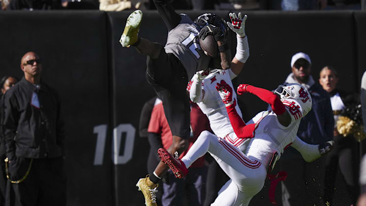 Colorado Buffaloes wide receiver Travis Hunter pulls in a reception over Utah Utes cornerbacks Smith Snowden and Cameron Calhoun.