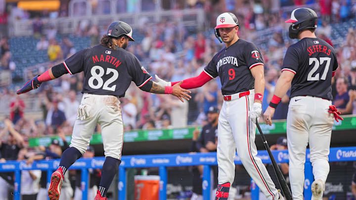 Jun 18, 2024; Minneapolis, Minnesota, USA; Minnesota Twins outfielder Austin Martin (82) celebrates his run with designated hitter Trevor Larnach (9) and catcher Ryan Jeffers (27) against the Tampa Bay Rays in the fourth inning at Target Field. Mandatory Credit: Brad Rempel-Imagn Images